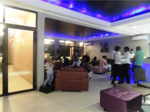 a group of people in a lobby with purple lights at Bella Casa Hotel in Monrovia