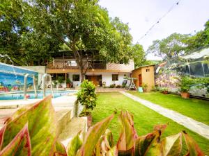 une cour arrière avec une piscine et une maison dans l'établissement Cabaña Casa Lila, à Santa Marta