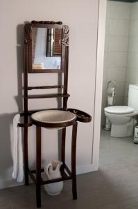a bathroom with a toilet, sink and mirror at Patio de Arance in Málaga
