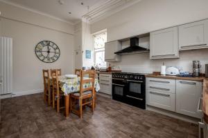 a kitchen with a table and chairs and a clock on the wall at St Albans Lower - Elie in Earlsferry