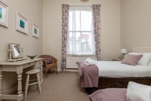 a bedroom with two beds and a desk and a window at St Albans Lower - Elie in Earlsferry
