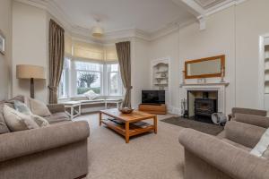 a living room with two couches and a fireplace at St Albans Lower - Elie in Earlsferry
