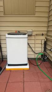 a cooler sitting outside of a house with a green hose at Only 20 a night-Special offer-Man's Bed in Texas City