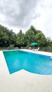 een blauw zwembad met een tafel en een parasol bij Quinta La Gloria in La Plata +25 foto's