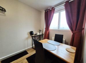 een eetkamer met een tafel en een raam bij Studio Terra in Ploërmel