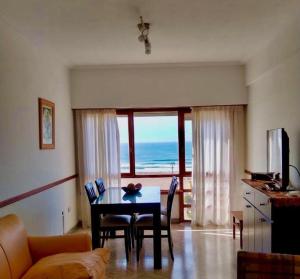 a living room with a table and a view of the ocean at Amanecer del Mar in Necochea