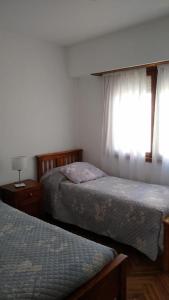 a bedroom with two beds and a window at Amanecer del Mar in Necochea +5 photos