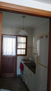 a kitchen with a refrigerator and a stove top oven at Amanecer del Mar in Necochea