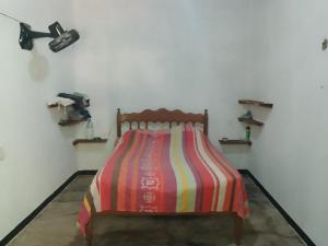 un letto con un piumone colorato a righe in una stanza di fusio ad Alter do Chão