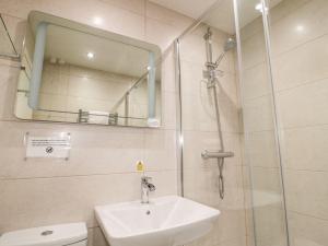 a bathroom with a sink and a shower with a mirror at Primrose Cottage in Chathill +8 photos