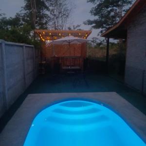 a swimming pool in a backyard at night with an umbrella at Refugio las Mariposas Chillán in Chillán