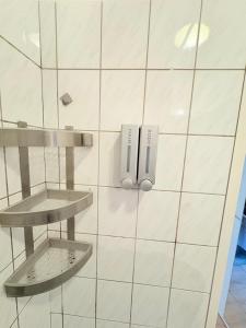 a white tiled bathroom with a phone on the wall at Beenie 19 in Linz +25 photos