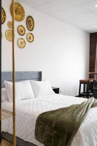 a bedroom with a bed with plates on the wall at Golden Hour @TheMillRowsSuites in New Glasgow
