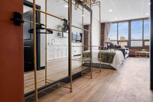 a bedroom with a bed and a living room at Golden Hour @TheMillRowsSuites in New Glasgow