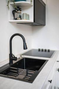 a kitchen with a sink and a black sink at The Classic @TheMillRowsSuites in New Glasgow