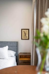 a bedroom with a bed and a table and a picture at The Classic @TheMillRowsSuites in New Glasgow +11 photos