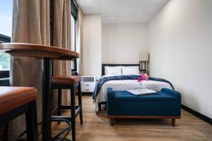 a hotel room with a bed and a blue ottoman at Blue Room @ The MillRows Suites in New Glasgow