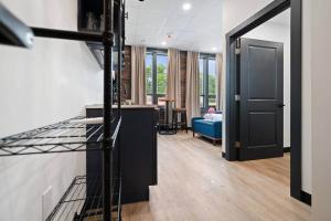 a kitchen with a black door and a living room at Blue Room @ The MillRows Suites in New Glasgow