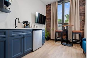 a kitchen with a sink and a counter with a table at Blue Room @ The MillRows Suites in New Glasgow