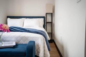 a bedroom with a bed and a blue chair at Blue Room @ The MillRows Suites in New Glasgow +4 photos