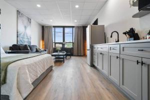a bedroom with a large bed and a kitchen at Game Night @ The MillRows Suites in New Glasgow
