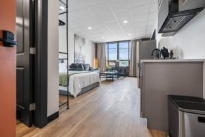 a hotel room with a bed and a kitchen and a bathroom at Game Night @ The MillRows Suites in New Glasgow
