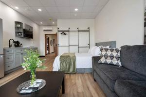 a living room with a couch and a bed at Game Night @ The MillRows Suites in New Glasgow