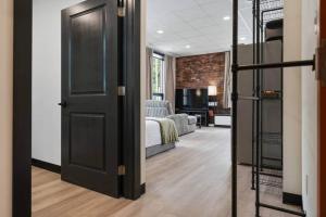 a room with a bedroom with a bed and a door at The Library @TheMillRowsSuites in New Glasgow