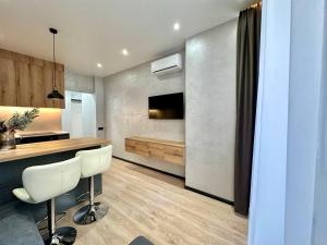 a kitchen with a counter and a bar with a sink at Central Park Apart Irpin in Irpin