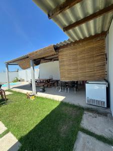 a patio with a wooden pergola and a picnic table at Espaço massagueira in Marechal Deodoro +1 photo