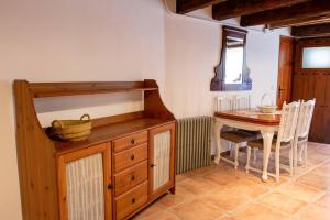 a kitchen with a table and a wooden dresser at Casa Rural Dauden 3 Habitaciones in Cantavieja +8 photos