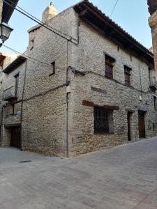 a large brick building with windows on the side at Casa Rural Dauden 3 Habitaciones in Cantavieja