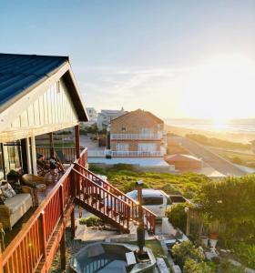 una vista di una casa con un ponte e un balcone di 360onSea a De Kelders
