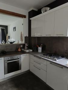 a kitchen with white cabinets and a stove top oven at Lonzee in Gembloux