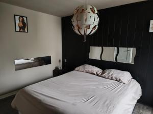a bedroom with a white bed with a black wall at Lonzee in Gembloux
