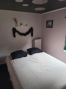 a bedroom with a bed with a comforter on the wall at Lonzee in Gembloux