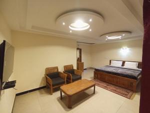 a bedroom with a bed and a couch and a table at The Hill Bunk Heights Ooty in Ooty