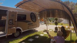 a person taking a picture of a camper under a tent at Güneş' te Karavan Otel in Karaburun