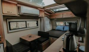 an interior view of an rv with a table and a room at Güneş' te Karavan Otel in Karaburun