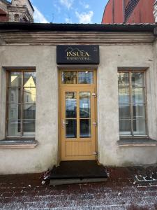 a building with a yellow door and windows at Insula Poilsio Namai in Telšiai +3 photos