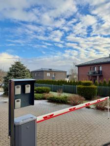 a parking lot with a gate and a trash can at Insula Poilsio Namai in Telšiai