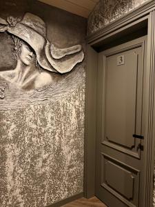 a painting of a woman on a wall next to a door at Insula Poilsio Namai in Telšiai