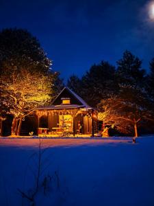 una casa è illuminata di notte con luci di Skujiņa a Princmuiza
