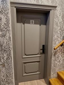 a gray door with a window in a hallway at Insula Poilsio Namai in Telšiai