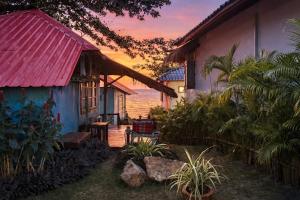 a house with a red roof in front of the ocean at Blue Sky Resort in Ko Chang