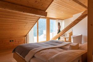 Eine Frau steht in einem Schlafzimmer mit einem großen Bett in der Unterkunft Meisser Romantica "adults only" in Guarda