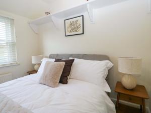 a bedroom with a bed with white sheets and pillows at Tram Lane Cottage in Carnforth