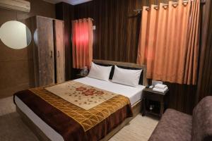 a hotel room with a bed and a chair at Hotel Sudarshan By Nath Bliss - Near Shrinathji Temple Just 2 Mins Walk in Nāthdwāra