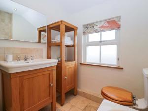 a bathroom with a sink and a toilet and a window at Tram Lane Cottage in Carnforth +29 photos