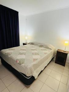 een slaapkamer met een bed met twee nachtkastjes en twee lampen bij Apartment with a private backyard in Los Molles +5 foto's